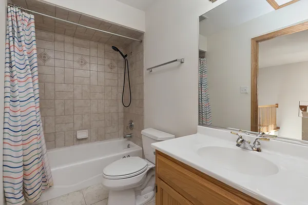 a bathroom with a granite countertop sink toilet mirror and bathtub