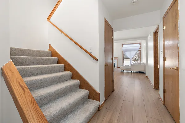 a view of a hallway with wooden floor and staircase