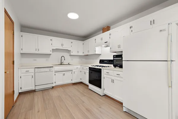 a kitchen with granite countertop white cabinets and white appliances