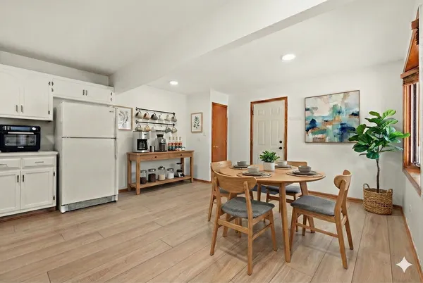 a kitchen with stainless steel appliances a table and chairs in it