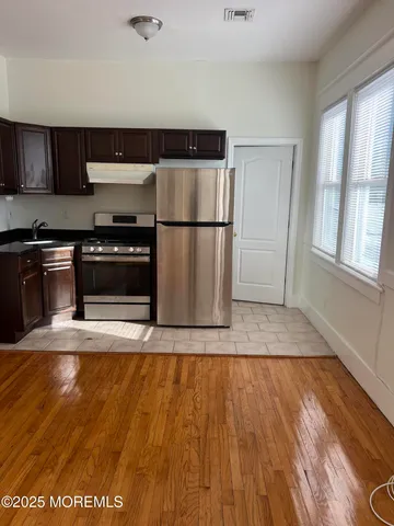a kitchen with wooden floors and black appliances