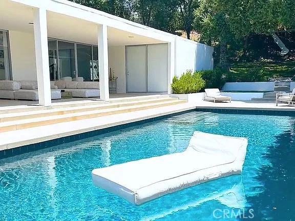 a view of a house with backyard patio and swimming pool