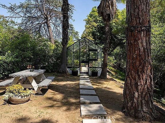 1030 San Rafael Lane Pasadena, CA 91105 - Photo 28 of 56 a view of a patio with table and chairs with wooden fence and plants
