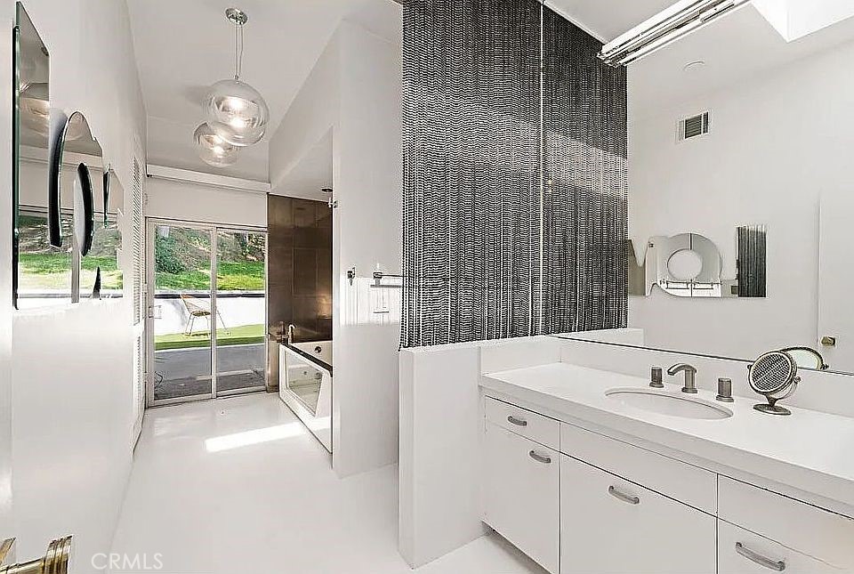 1030 San Rafael Lane Pasadena, CA 91105 - Photo 29 of 56 a bathroom with a sink a large mirror and a shower