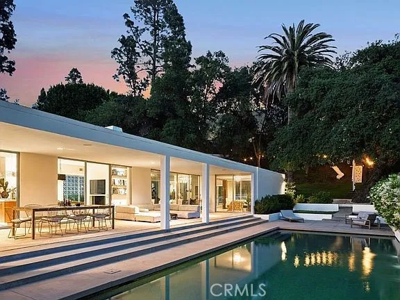 a view of a house with swimming pool and sitting area