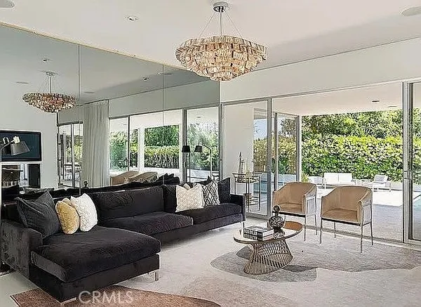 a living room with furniture and floor to ceiling windows