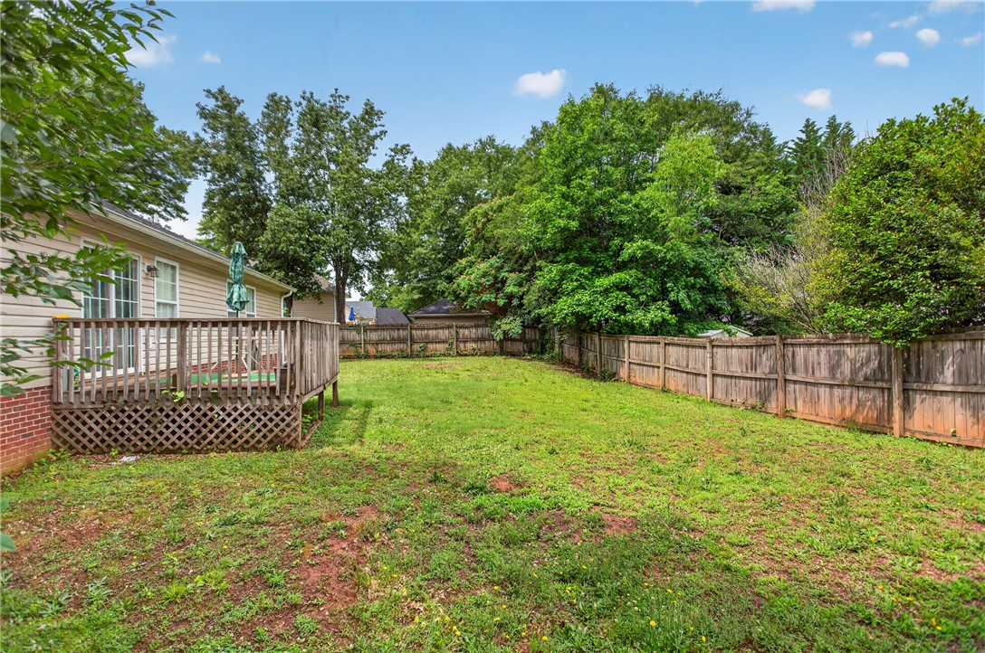 207 Hunters Lane Anderson, SC 29625 - Photo 7 of 46 A spacious yard with a wooden privacy fence, perfect for outdoor living and recreation.