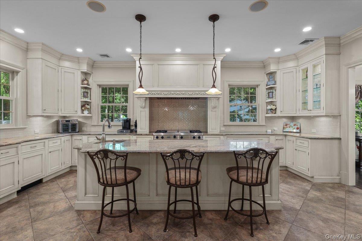 135 Pines Bridge Road Katonah, NY 10536 - Photo 3 of 40 a kitchen with a dining table chairs wooden cabinets and white appliances