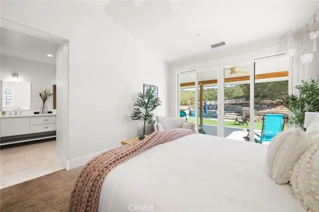 a bedroom with a bed and large windows