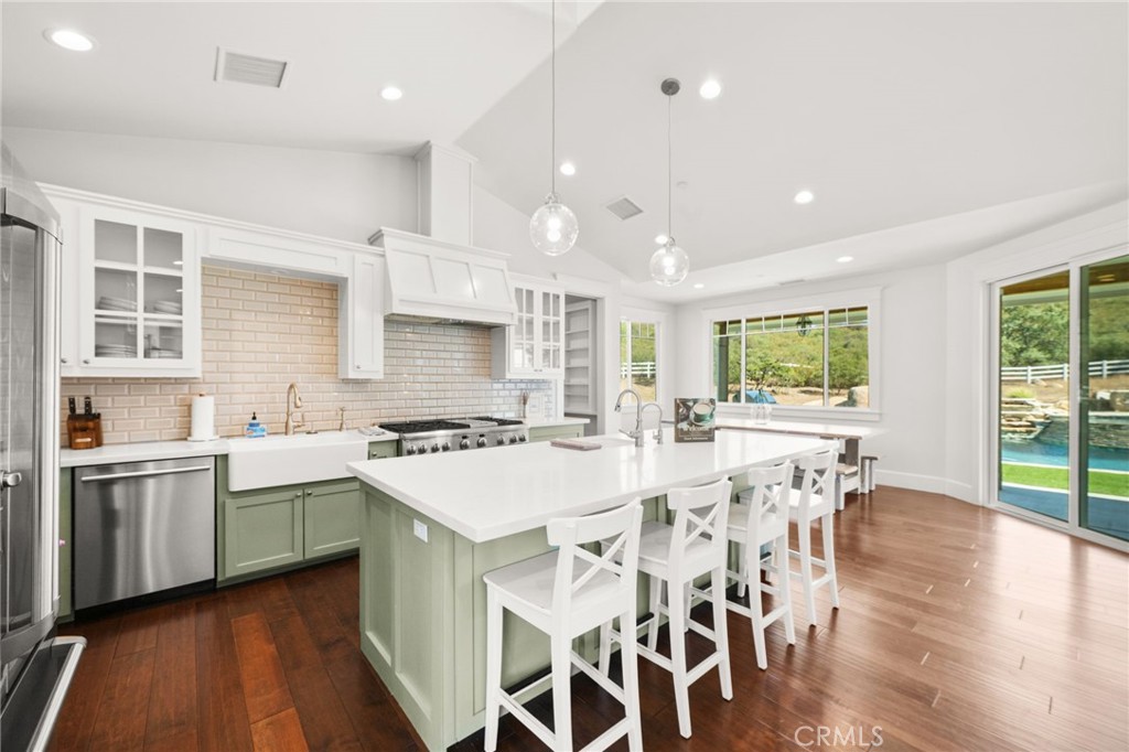 41260 De Anna Ranch Road Murrieta, CA 92562 - Photo 8 of 57 a kitchen with stainless steel appliances granite countertop a stove top oven a sink dishwasher a dining table and chairs with wooden floor