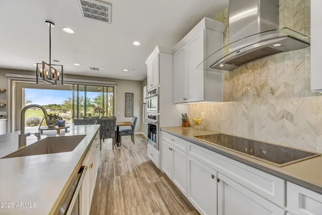 a large kitchen with kitchen island a large counter space a sink and stainless steel appliances