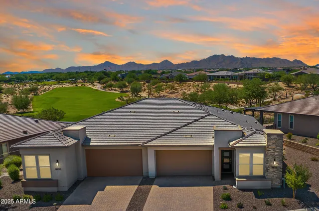 an aerial view of residential houses with outdoor space and trees
