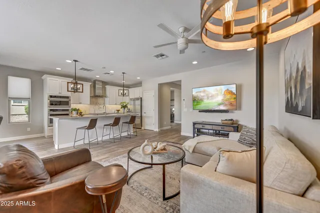 a living room with furniture kitchen view and a flat screen tv