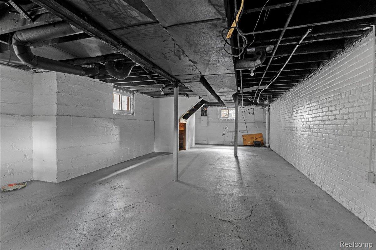 58 East Philadelphia Street Detroit, MI 48202 - Photo 22 of 24 Expansive basement featuring painted brick walls, exposed ceiling joists, and concrete flooring