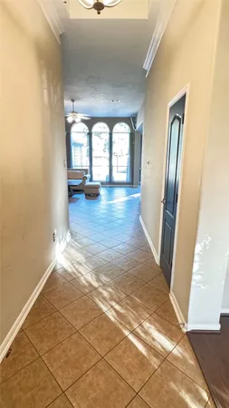 a view of a hallway with wooden floor and a bathroom