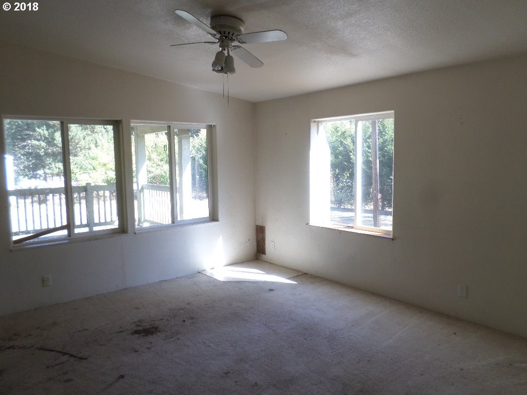 15063 South Hattan Road Oregon City, OR 97045 - Photo 12 of 25 an empty room with windows and fan