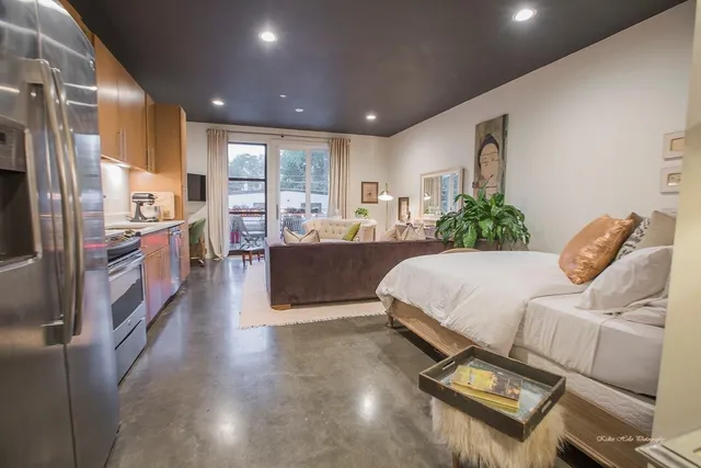 a large bedroom with bed furniture and a large window