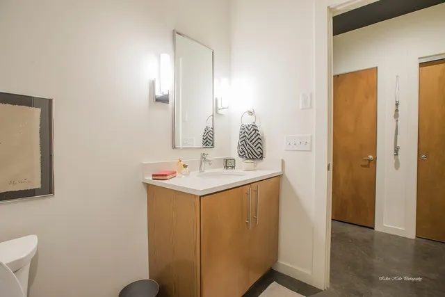a bathroom with a sink a toilet and mirror