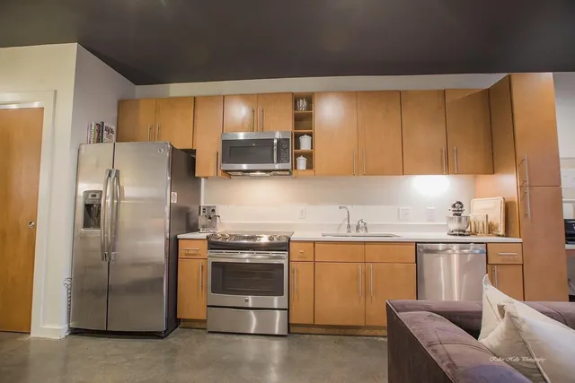 a kitchen with stainless steel appliances a stove a sink and a refrigerator