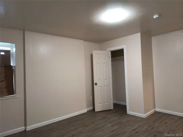 an empty room with wooden floor and closet