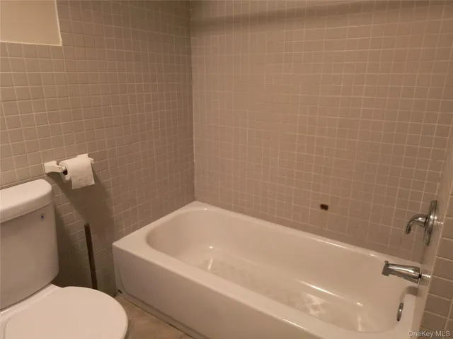 a white bath tub sitting next to a white toilet