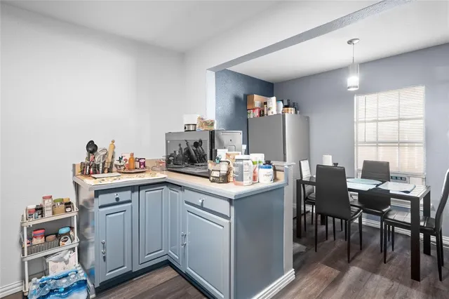 a kitchen with granite countertop cabinets a sink dishwasher and a dining table with wooden floor