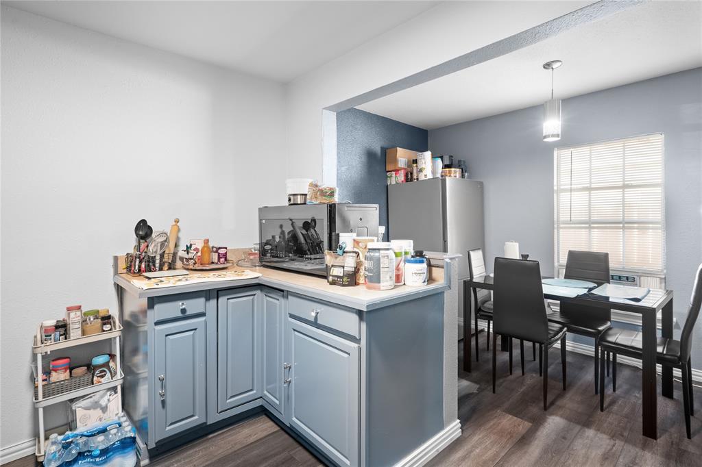 4115 Peachtree Road Balch Springs, TX 75180 - Photo 11 of 24 a kitchen with granite countertop cabinets a sink dishwasher and a dining table with wooden floor
