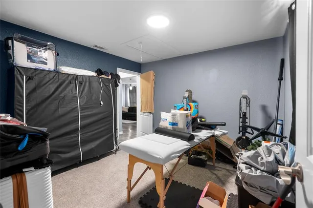 a living room with furniture a flat screen tv and gym equipment