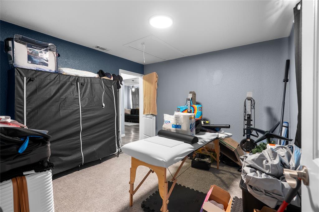 4115 Peachtree Road Balch Springs, TX 75180 - Photo 16 of 24 a living room with furniture a flat screen tv and gym equipment