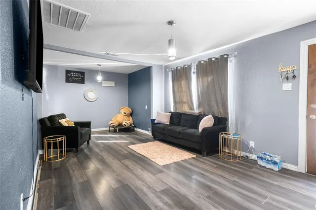 a living room with furniture a flat screen tv and gym equipment