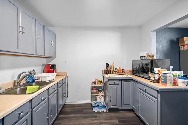 a kitchen with cabinets a sink and wooden floor