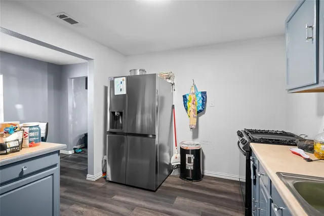 a kitchen with a refrigerator and a stove top oven