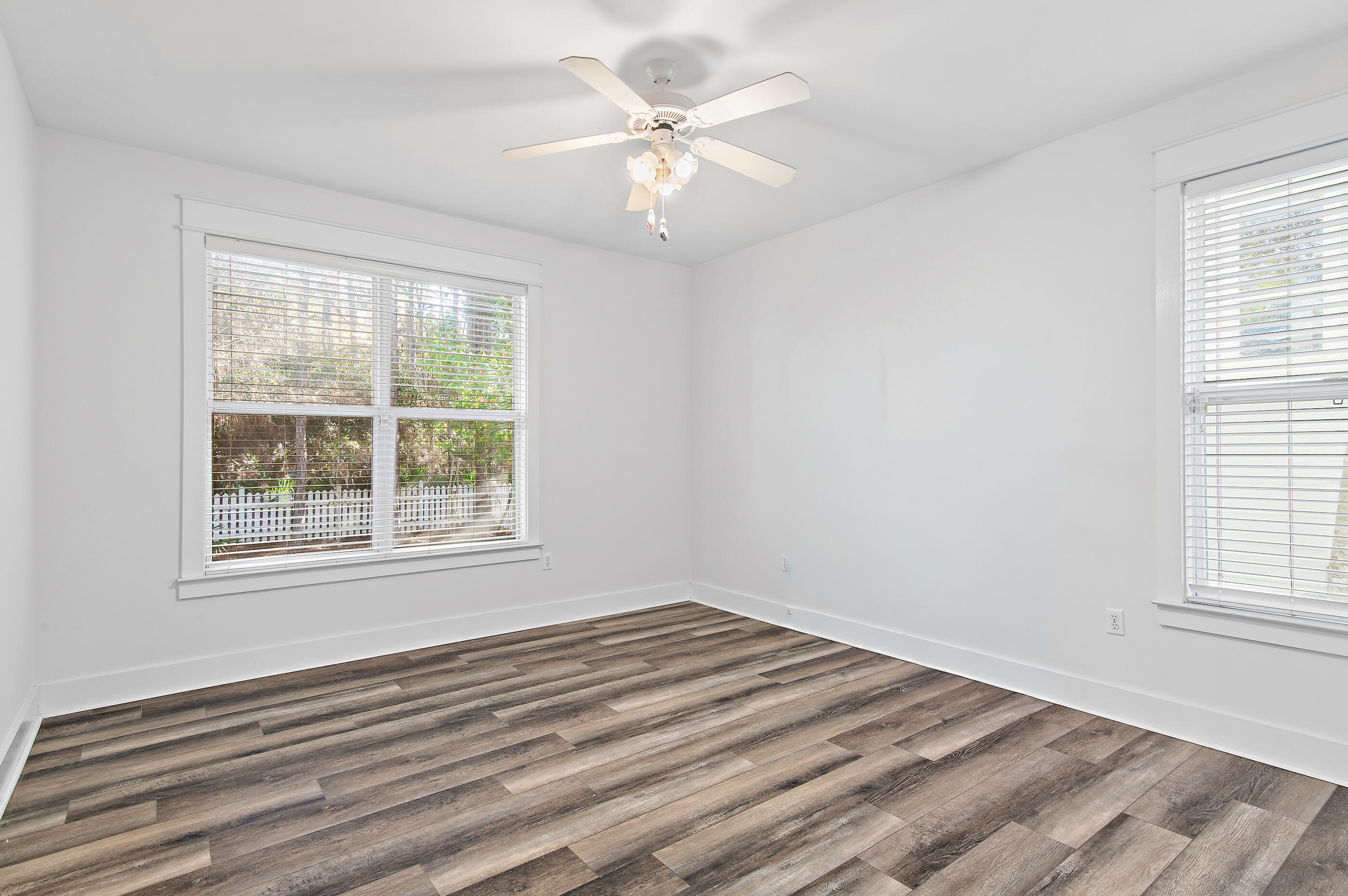 158 Cullman Avenue Santa Rosa Beach, FL 32459 - Photo 20 of 47 an empty room with wooden floor chandelier fan and windows