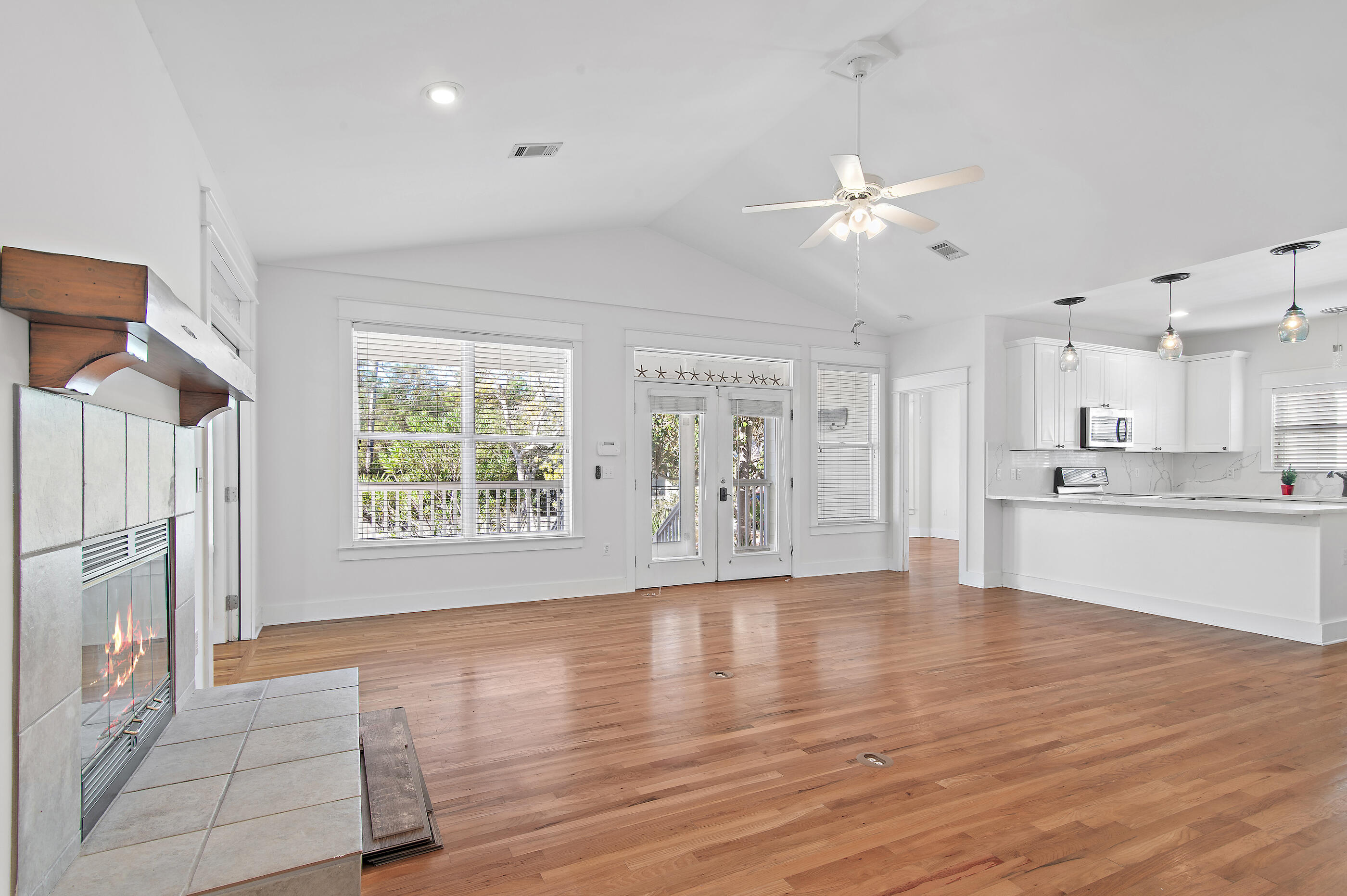 158 Cullman Avenue Santa Rosa Beach, FL 32459 - Photo 6 of 47 a view of an empty room with wooden floor and a kitchen