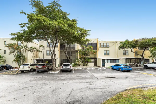 a view of road with card parked on side and retail shops