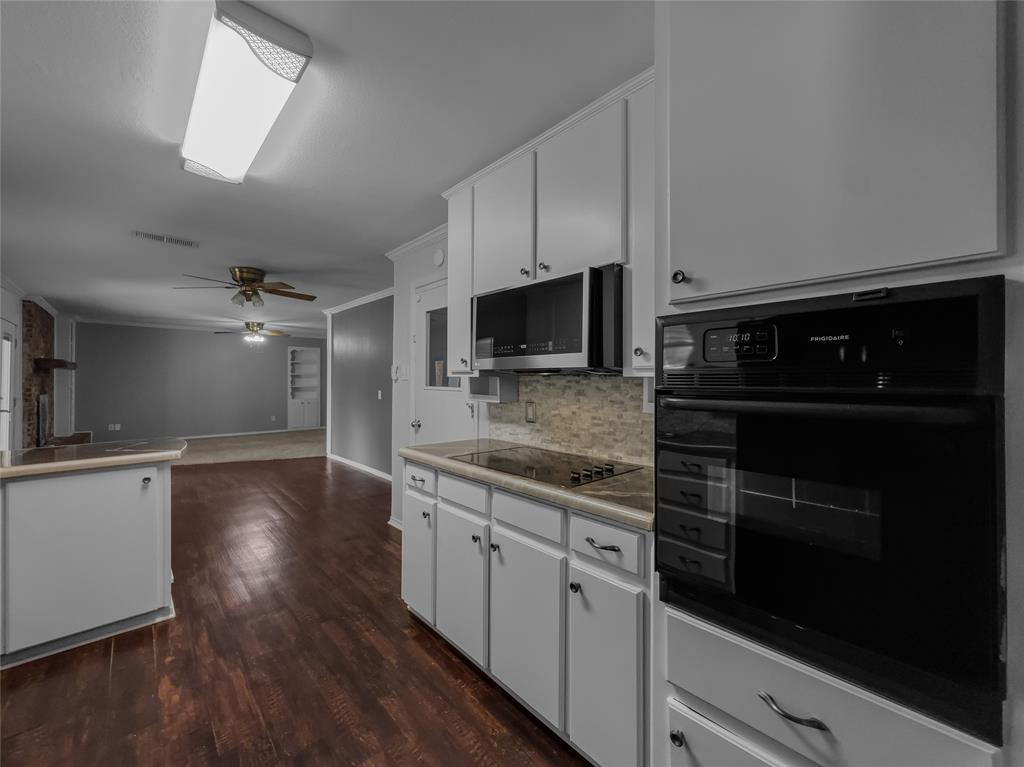 220 Cooper Drive Hurst, TX 76053 - Photo 9 of 27 a kitchen with stainless steel appliances kitchen island granite countertop a stove a sink and a microwave