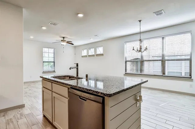 a kitchen with granite countertop a sink a stove and cabinets