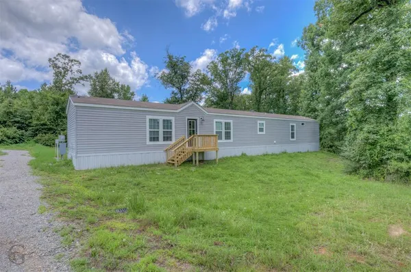 a view of a house with backyard and garden