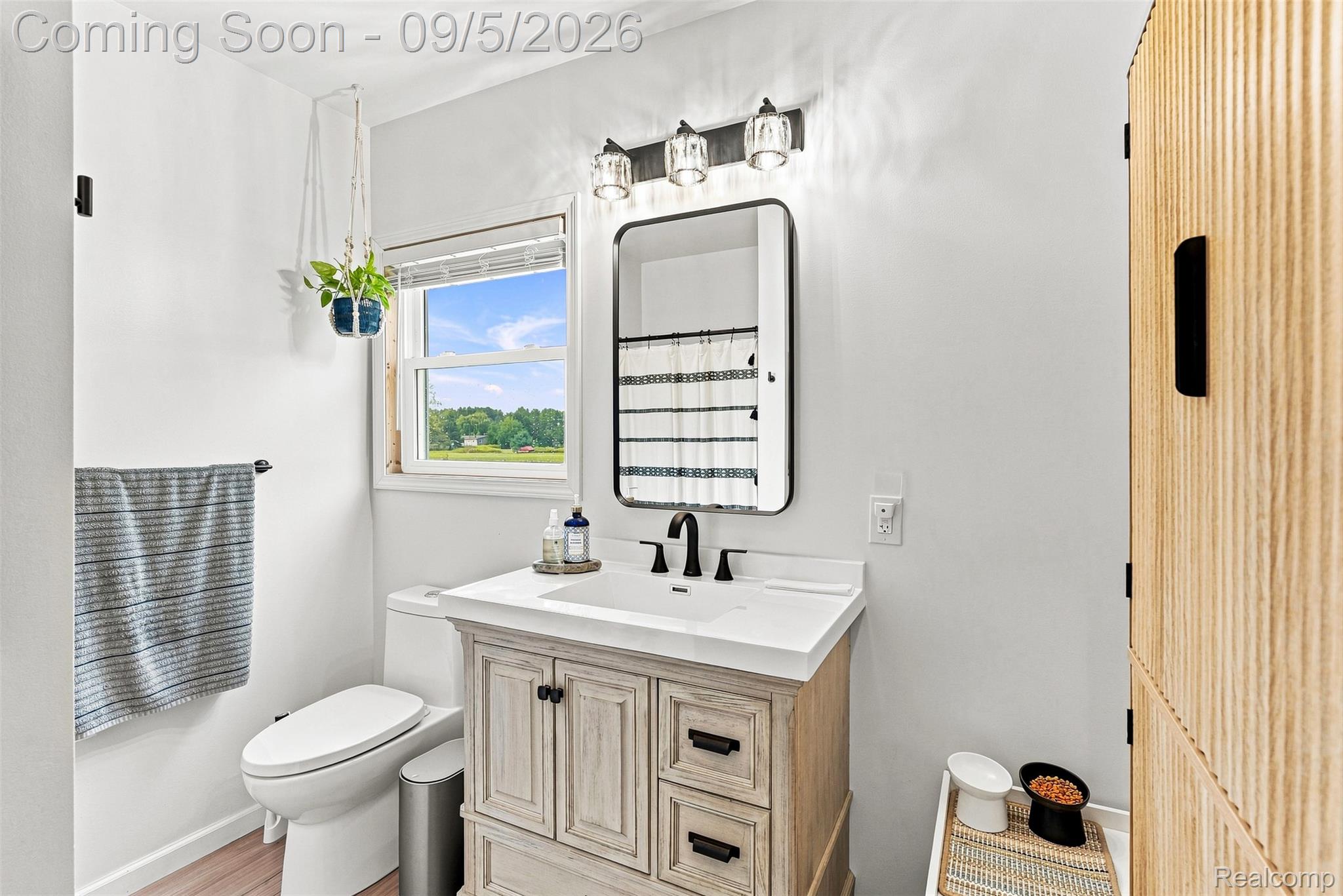 2071 East Dodge Road Clio, MI 48420 - Photo 33 of 38 White vanity with integrated sink, black faucet, and rectangular mirror