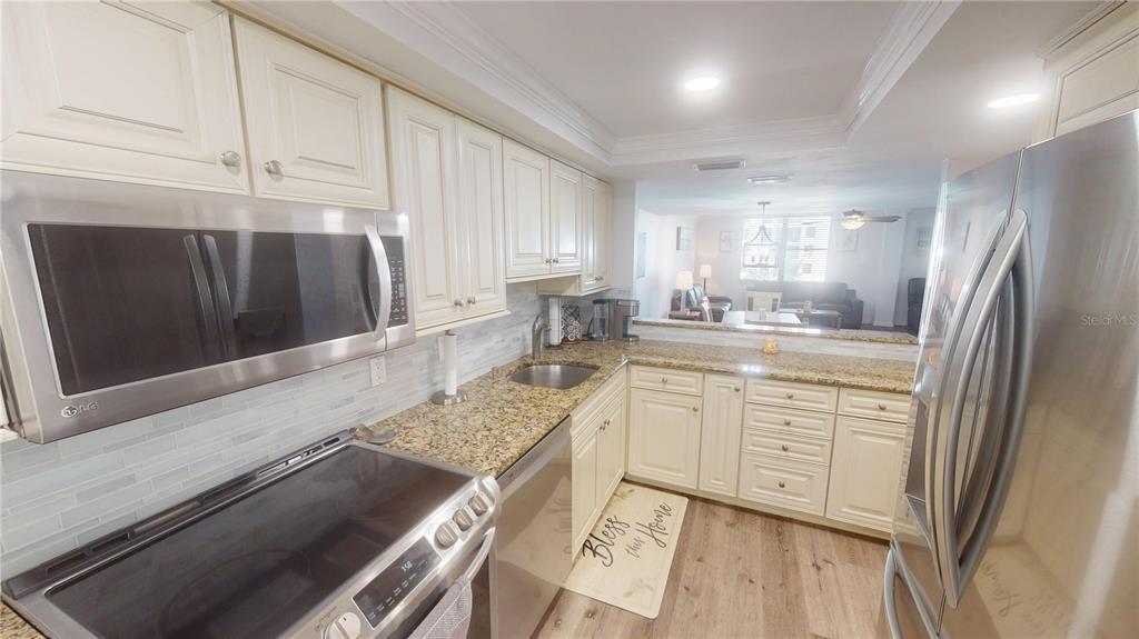 8735 Midnight Pass Road, Unit 206B Sarasota, FL 34242 - Photo 23 of 56 a kitchen with stainless steel appliances granite countertop a sink stove and refrigerator