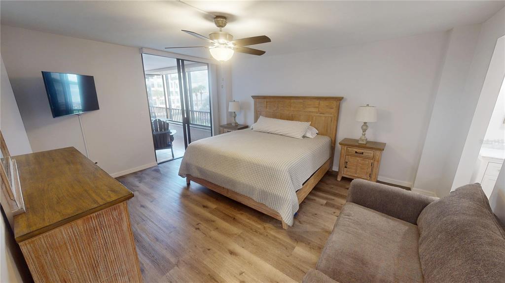 8735 Midnight Pass Road, Unit 206B Sarasota, FL 34242 - Photo 25 of 56 a bedroom with a bed flat screen tv and window