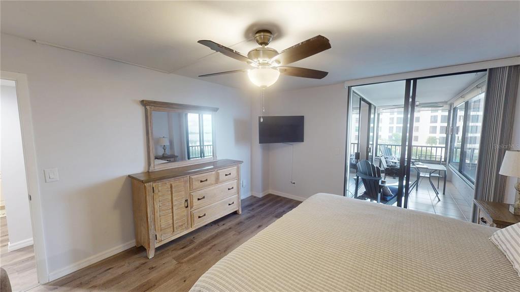 8735 Midnight Pass Road, Unit 206B Sarasota, FL 34242 - Photo 30 of 56 a bedroom with a bed and a chandelier