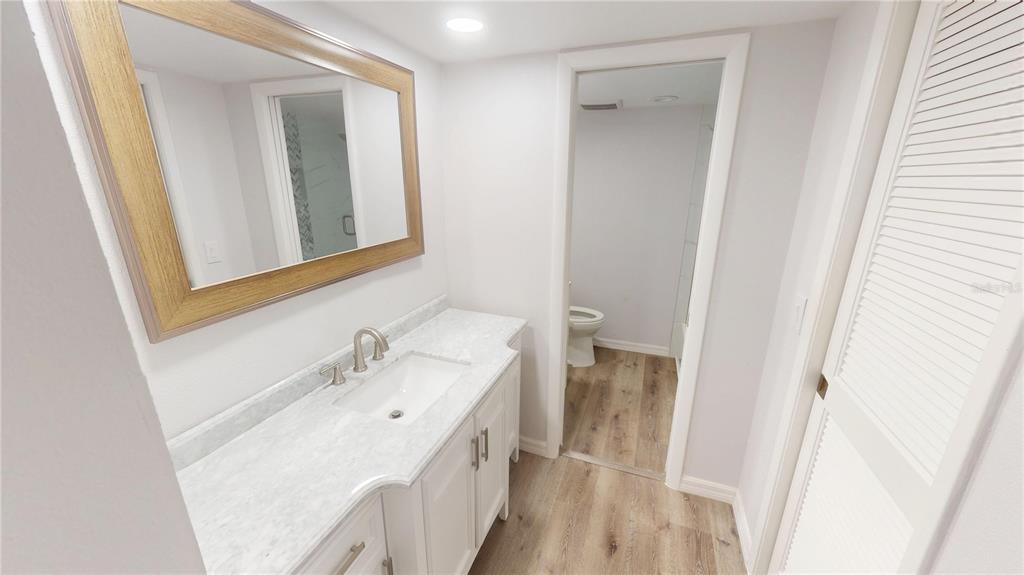 8735 Midnight Pass Road, Unit 206B Sarasota, FL 34242 - Photo 31 of 56 a bathroom with a sink a mirror and a vanity