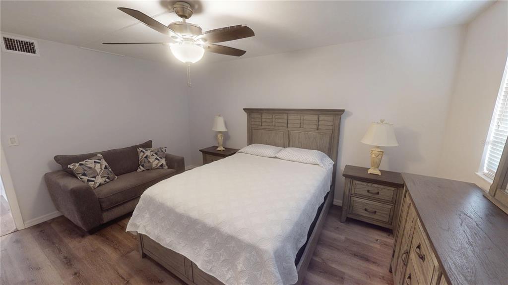 8735 Midnight Pass Road, Unit 206B Sarasota, FL 34242 - Photo 33 of 56 a bedroom with a bed and wooden floor