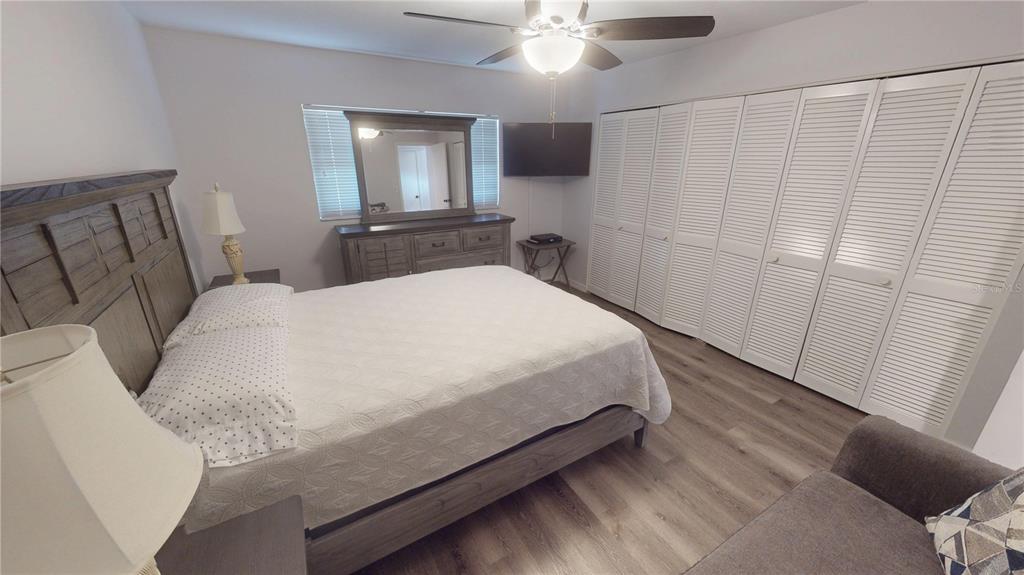 8735 Midnight Pass Road, Unit 206B Sarasota, FL 34242 - Photo 37 of 56 a bedroom with a bed and a mirror on dresser