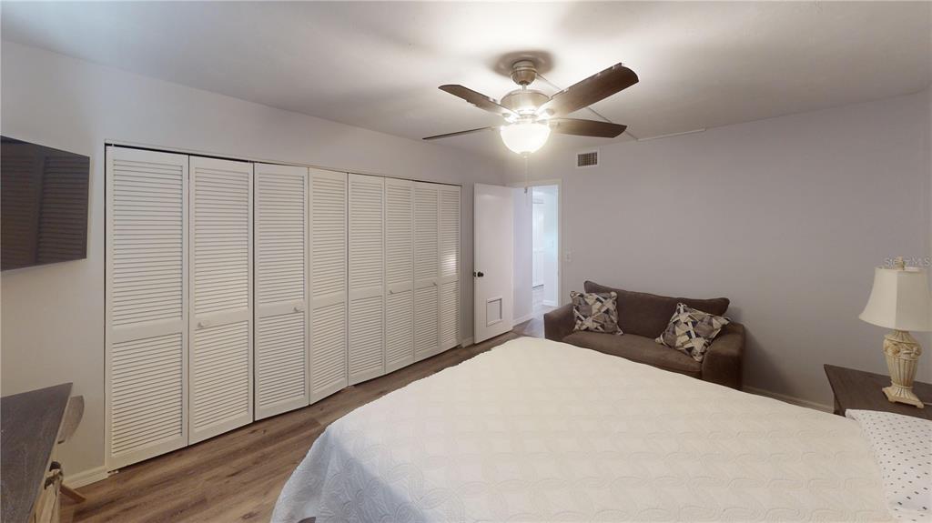 8735 Midnight Pass Road, Unit 206B Sarasota, FL 34242 - Photo 39 of 56 a bedroom with a large bed and a flat tv screen