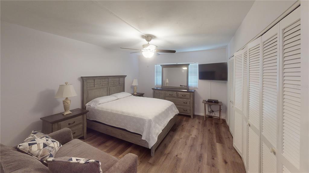 8735 Midnight Pass Road, Unit 206B Sarasota, FL 34242 - Photo 40 of 56 a bedroom with a bed and a television