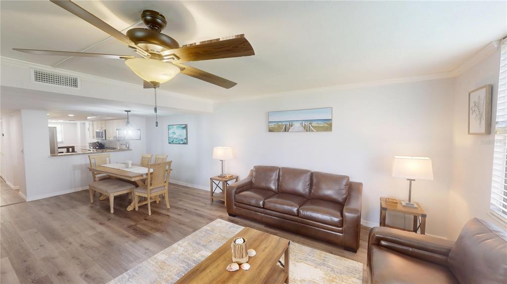 8735 Midnight Pass Road, Unit 206B Sarasota, FL 34242 - Photo 10 of 56 a living room with furniture and a chandelier