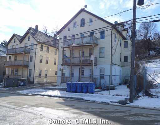 23-27 West Porter Street Waterbury, CT 06708 - Photo 1 of 1 a view of a big yard in front of a brick house
