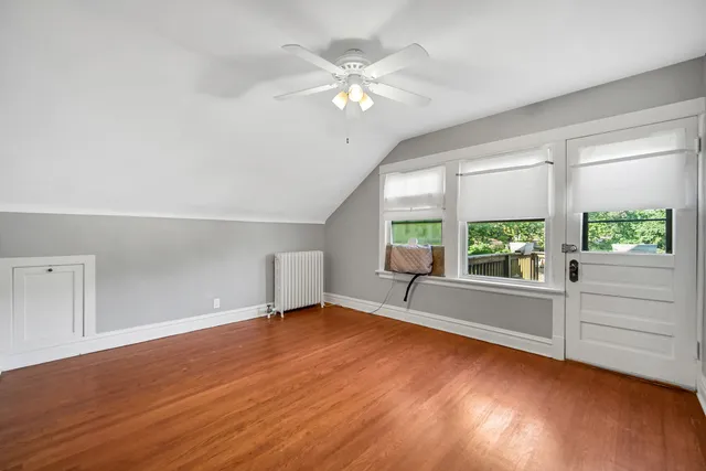 an empty room with windows and ceiling fan
